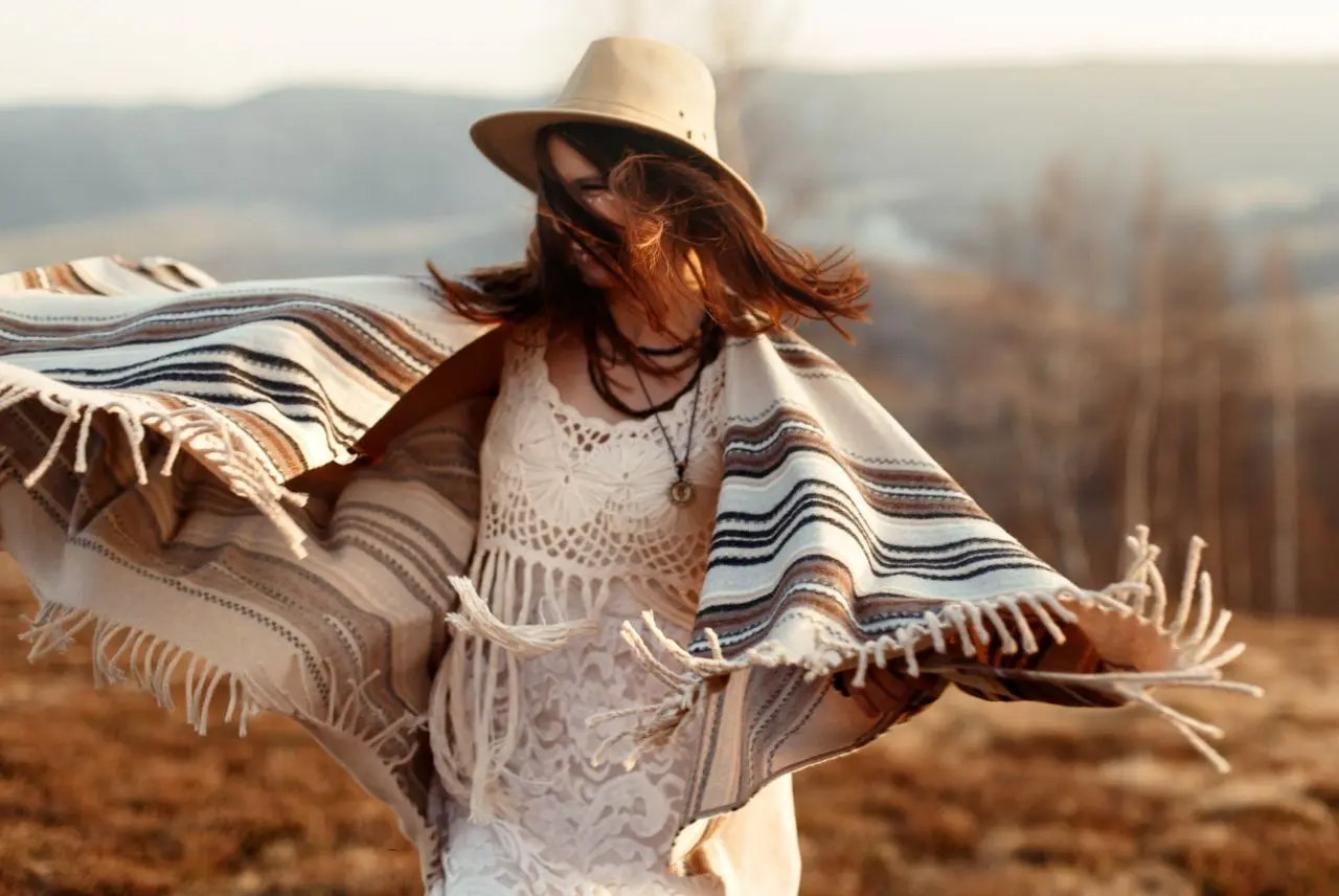 A woman wearing an Andean poncho dancing in a clearing
